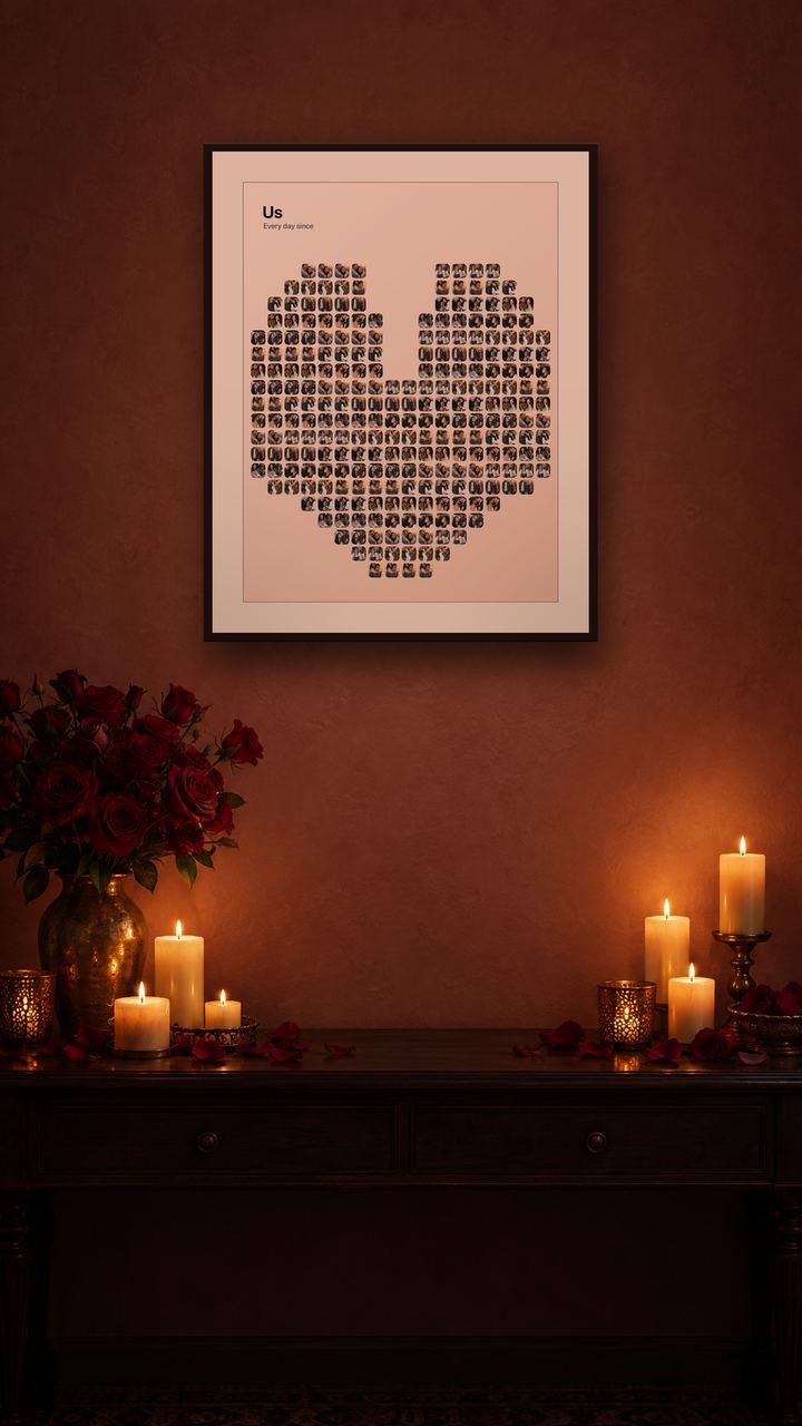 A heart-shaped photo collage of a couple titled Us, framed on a candlelit wall